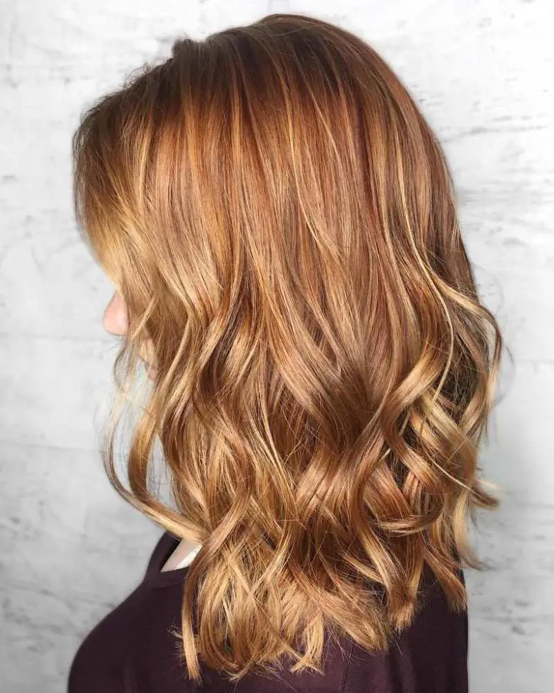 A perfect blend of copper with strawberry blonde highlights, cut to a lob